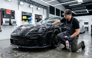 Car detailer cleaning a car in a professional car detailing studio