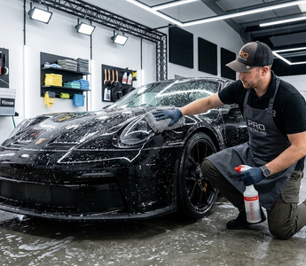 Car detailer cleaning a car in a professional car detailing studio