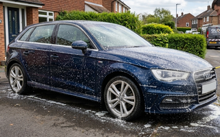 Detailer spraying citrus pre wash on a car and leaving it to dwell