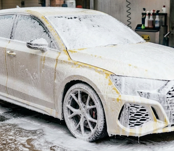 Yellow audi covered in a thick car snow foam